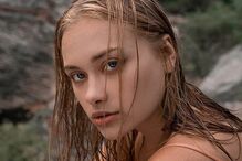 Retrato de uma mulher jovem com cabelo molhado e olhar fixo