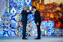 Cerimónia de entrega de medalha a um indivíduo, com azulejos e casario ao fundo