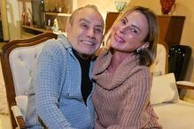 Casal posa sorridente para foto num ambiente acolhedor