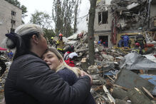 Equipas de resgate trabalham num prédio destruído após um ataque com mísseis russos em Kiev