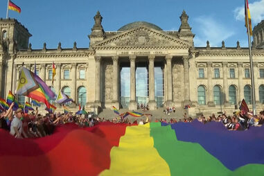 Bandeira arco-íris gigante estendida em frente ao parlamento alemão
