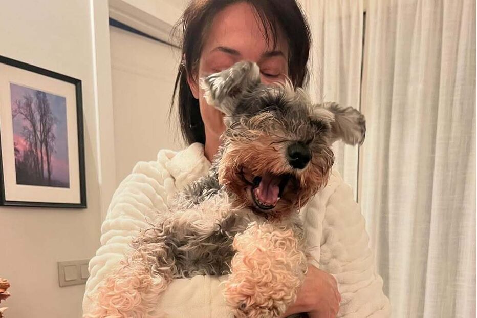 Paula Neves anuncia luto por perda importante, enquanto segura um cão.
