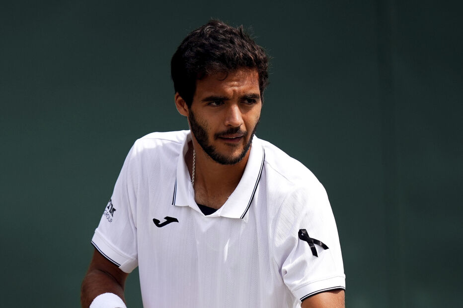 Jogador de ténis prepara-se para servir num court