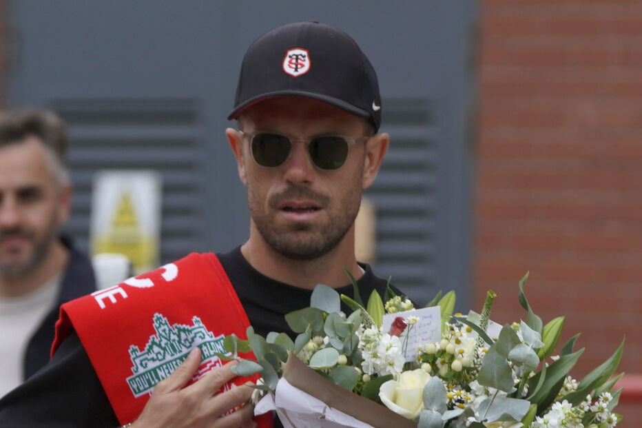 Jogador do Liverpool carrega flores e cachecol