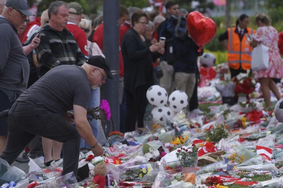 Pessoas prestam homenagem com flores e balões