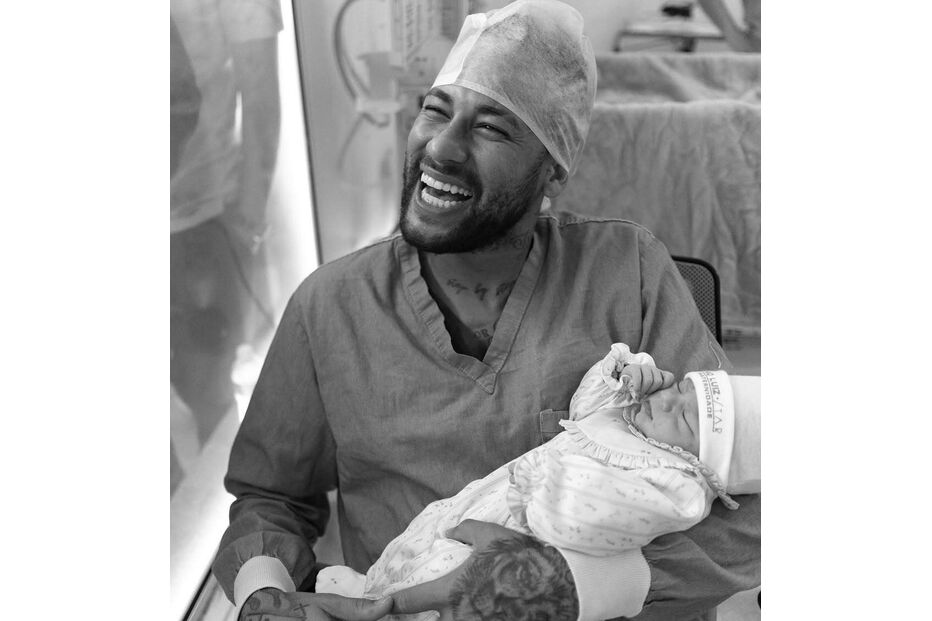 Neymar sorri com a filha, Mel, ao colo na maternidade