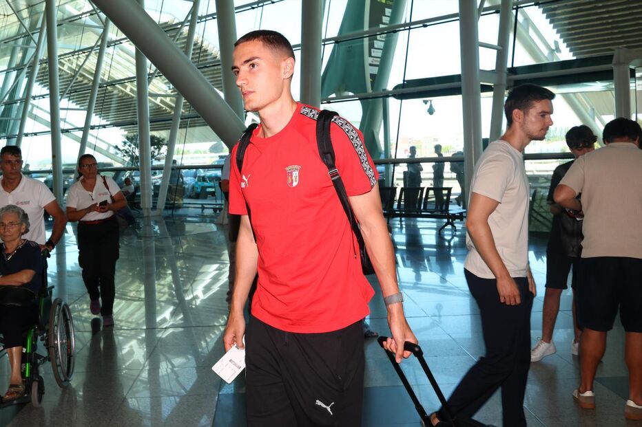 Passageiro no aeroporto transporta bagagem e bilhete de embarque