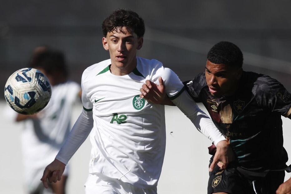 Jogadores de futebol em campo disputam a posse de bola durante o jogo