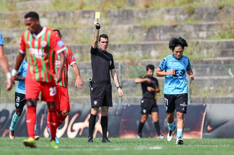 Árbitro mostra cartão amarelo durante jogo de futebol