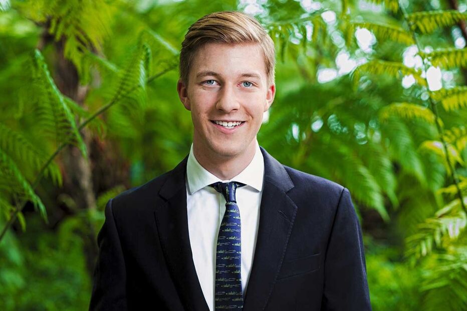 Retrato de um homem de fato e gravata num jardim