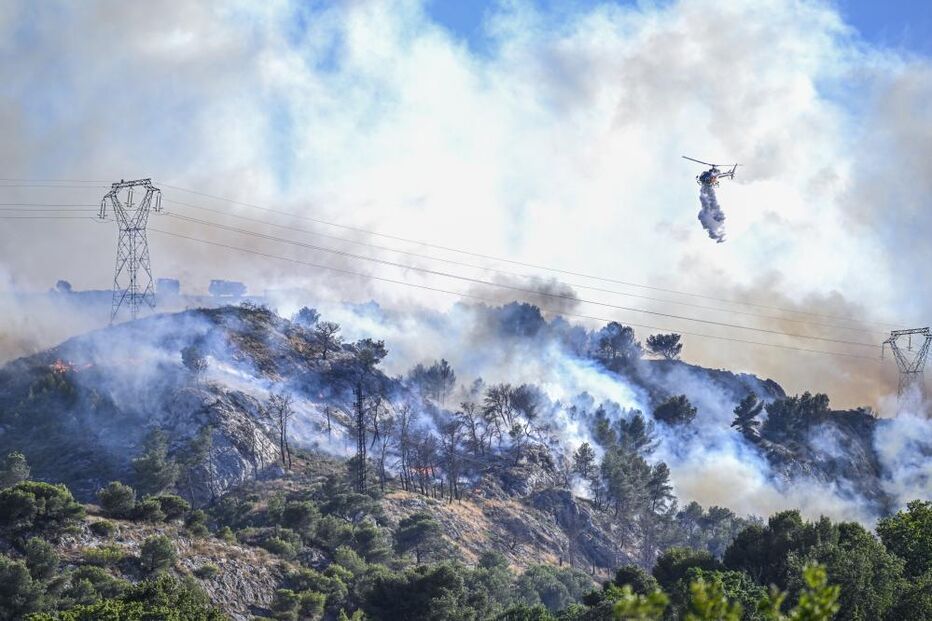 Helicóptero combate incêndio florestal numa zona montanhosa
