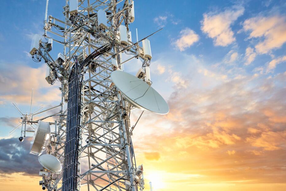 Antena de telecomunicações com céu alaranjado ao fundo