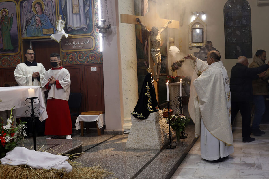 Pe. Gabriel Romanelli, pároco latino da Faixa de Gaza, reza durante a missa da meia-noite da véspera de Natal na Igreja Católica