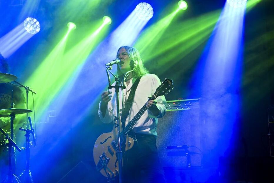 Músico atua num festival de verão com luzes e ambiente vibrante
