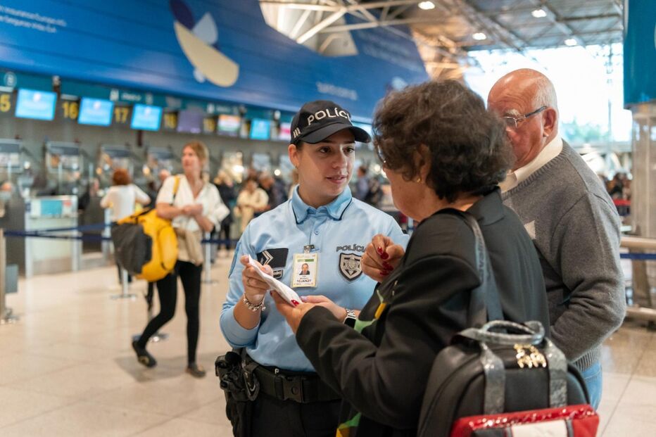 Agente da polícia interage com passageiros no aeroporto