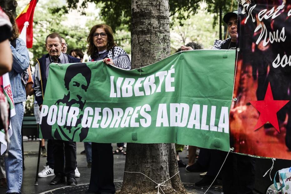 Mulher carrega faixa com a mensagem 