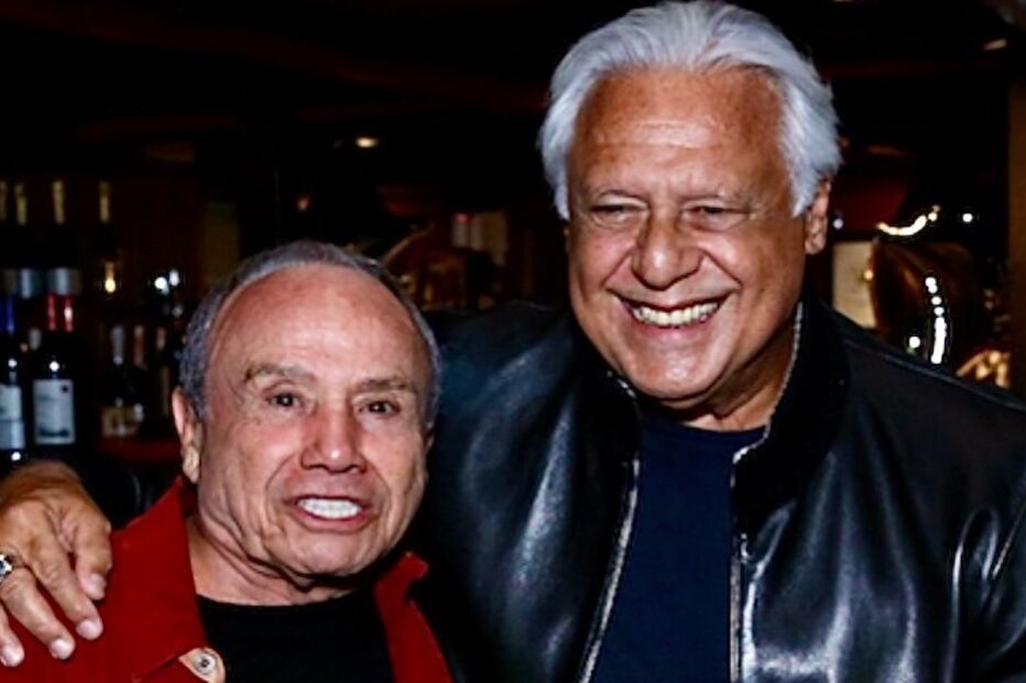 Dois homens sorriem para a câmara