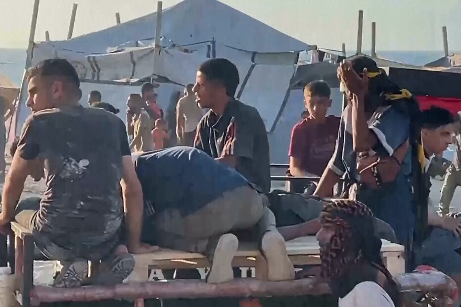 Palestinianos feridos a receberem ajuda após recolher alimentos em Gaza