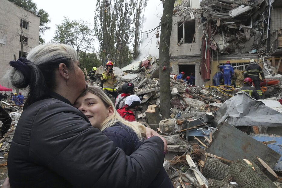 Mãe e filha abraçam-se em frente a destroços em Tchassiv Yar, Donetsk