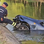Firefighters try to remove a car that skidded and fell into a ditch in Coimbra.