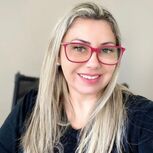 Mulher sorridente com óculos e cabelo comprido loiro
