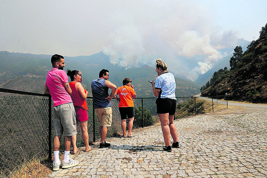 População observa a progressão do incêndio que se desenvolve em área de montanha no Parque Natural