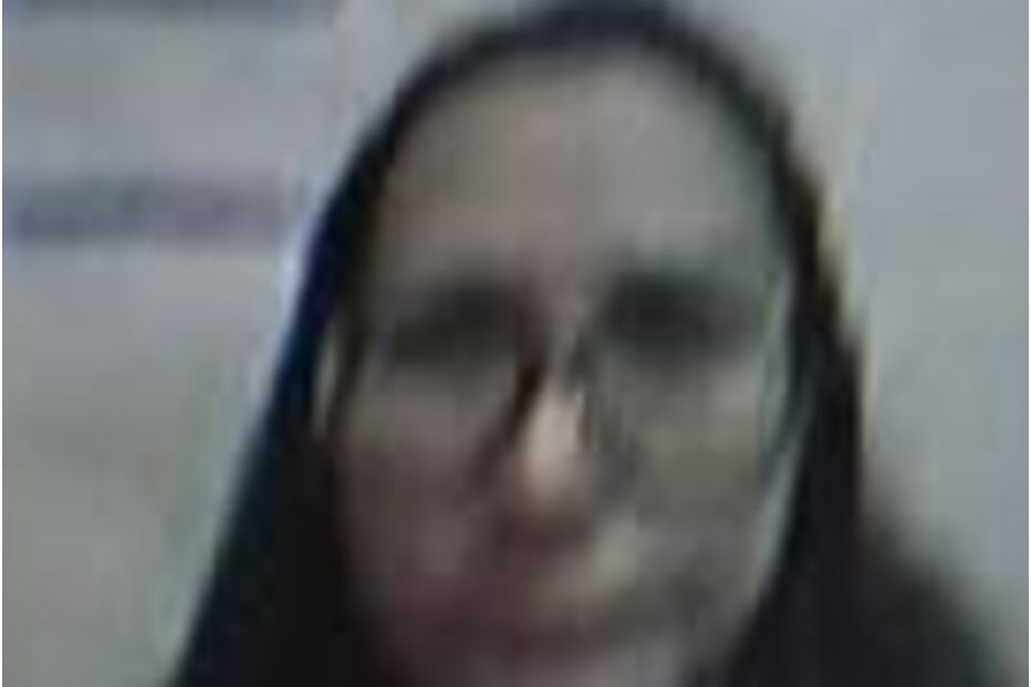 Mulher de óculos com texto ilegível ao fundo