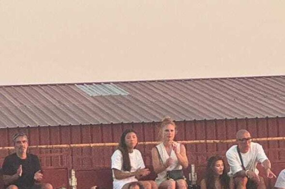 Pessoas assistem a evento em bancada