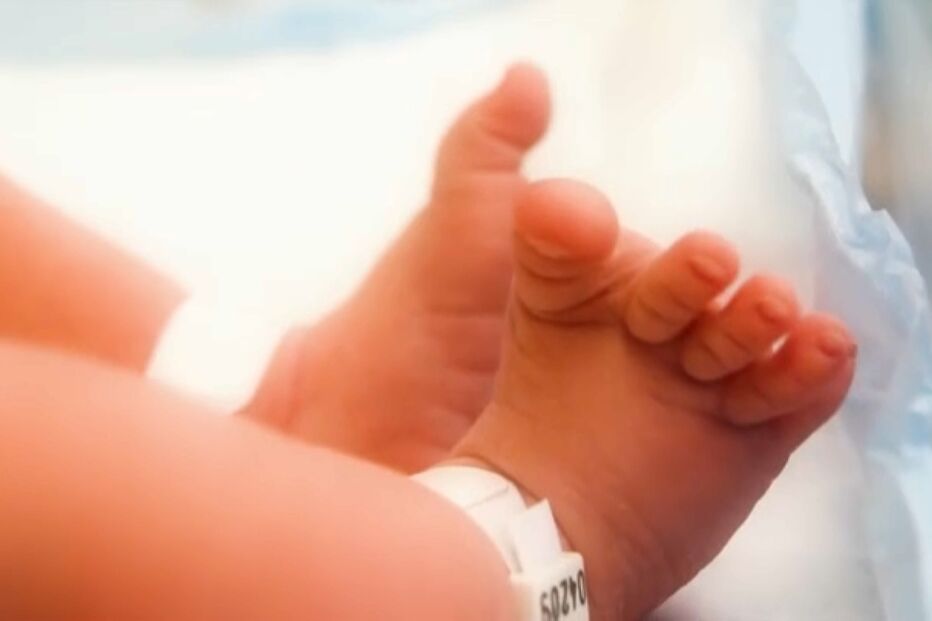 Pés de bebé com pulseira de identificação hospitalar