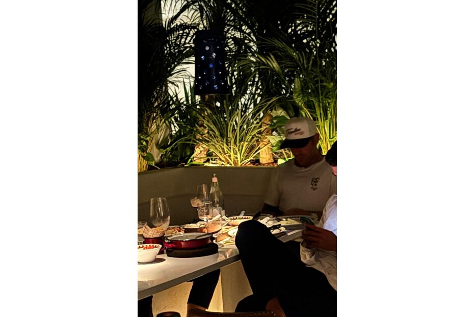 Pessoas jantam num ambiente com plantas