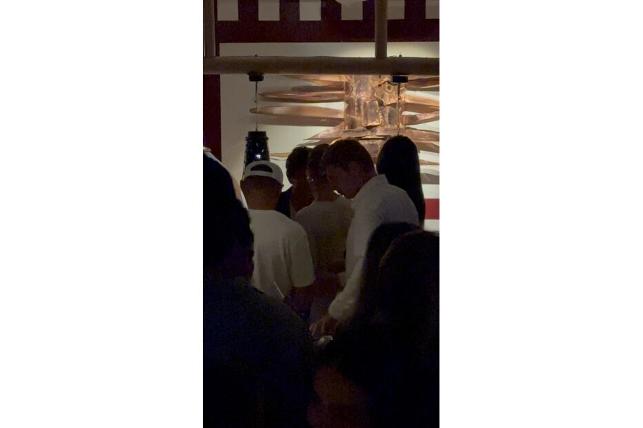 Pessoas reunidas num espaço interior, possivelmente um restaurante