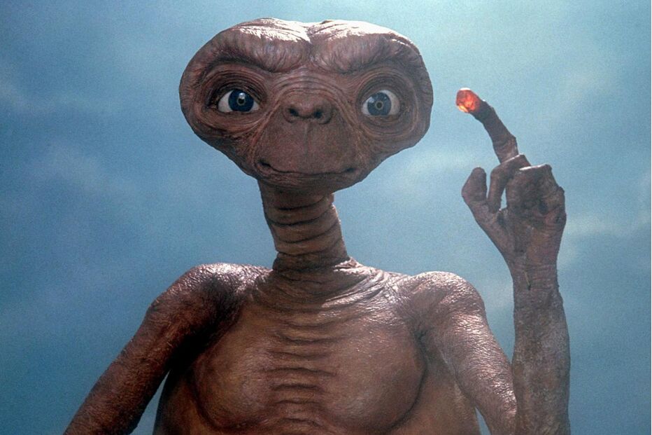 E.T., o extraterrestre, estende um dedo com uma luz vermelha brilhante na ponta
