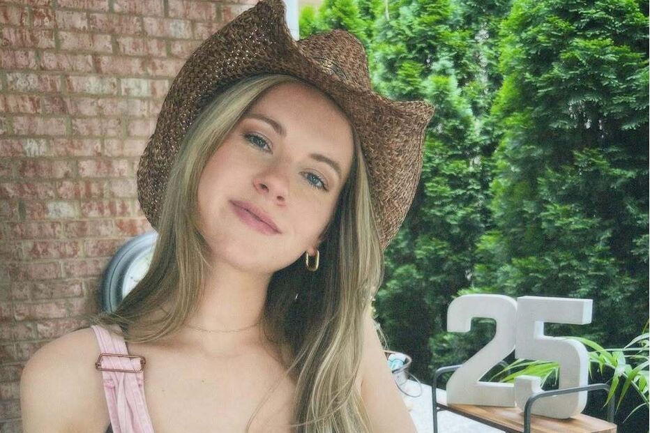 Jovem celebra 25 anos com chapéu de cowboy e macacão rosa num jardim