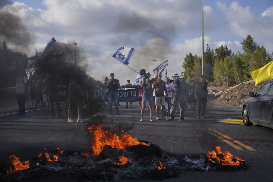 Manifestantes bloqueiam uma estrada durante protesto exigindo a libertação dos reféns mantidos pelo Hamas e pedindo que o governo israelita reverta a decisão de tomar a Cidade de Gaza