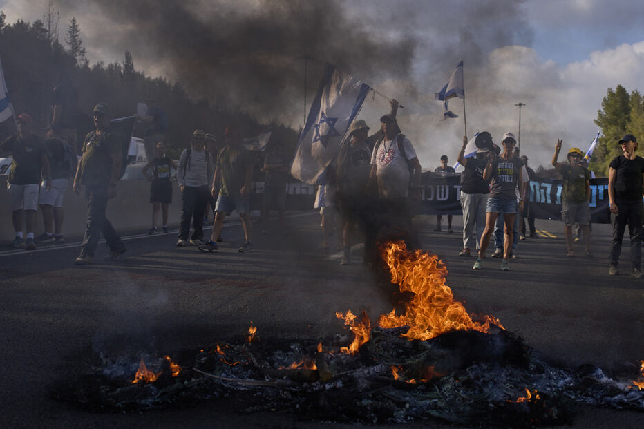 Manifestantes bloqueiam uma estrada durante protesto exigindo a libertação dos reféns mantidos pelo Hamas e pedindo que o governo israelita reverta a decisão de tomar a Cidade de Gaza