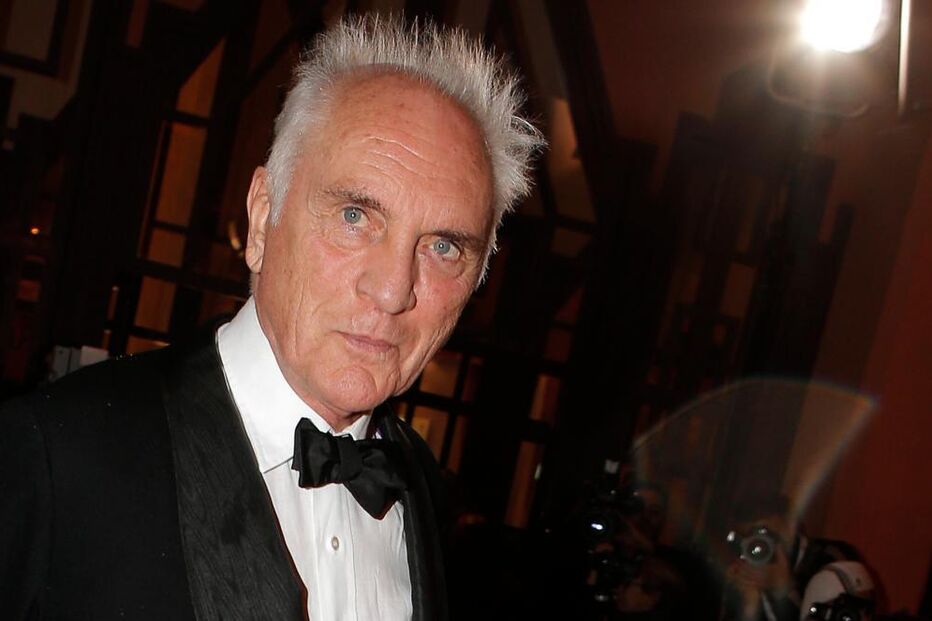 Retrato de Terence Stamp com fato e laço pretos num evento