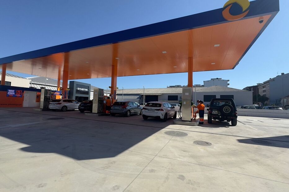 Posto de combustível com carros a abastecer e funcionários no local