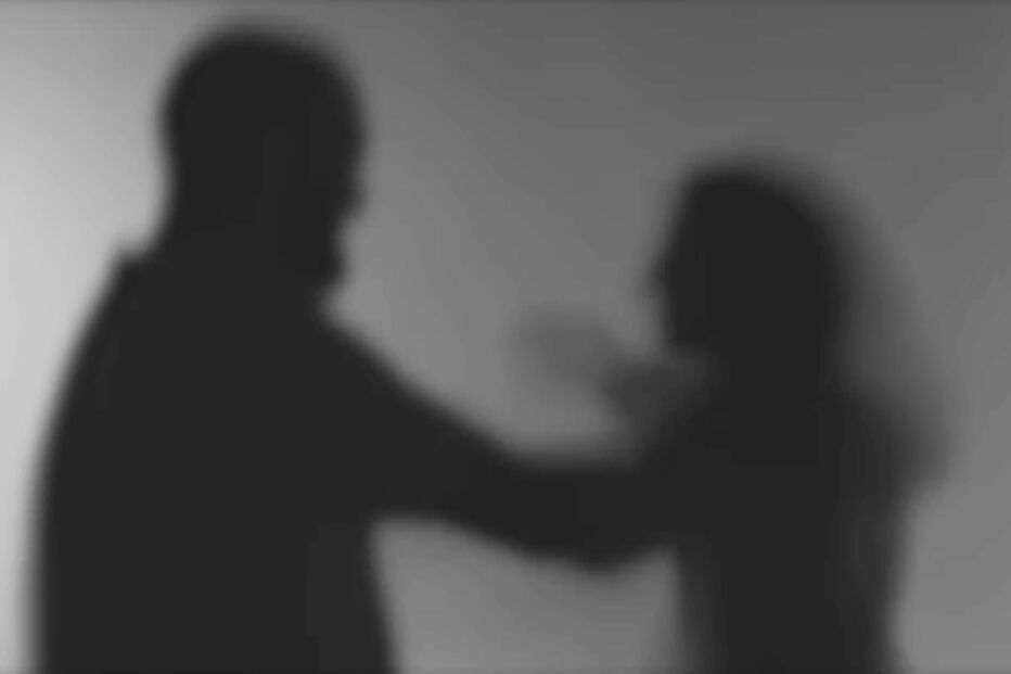 Silhuetas de homem e mulher em cena que sugere violência doméstica