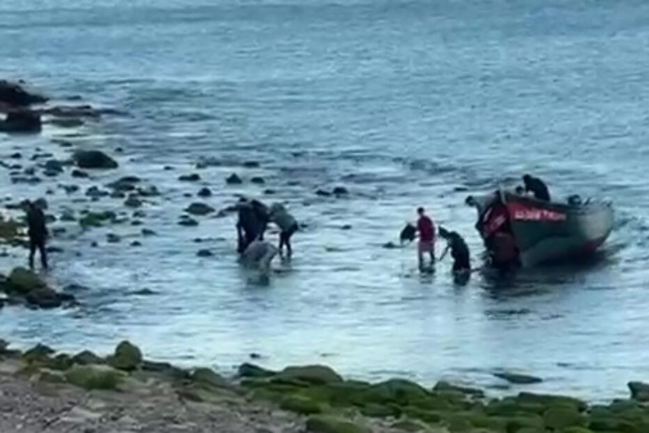 Pessoas desembarcam de barco na costa