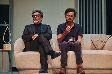 Dois homens sentados num sofá durante uma conversa