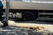 Camião com roda presa em buraco na via pública em Cascais