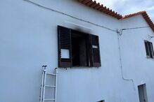 Incêndio danifica janela de casa branca com telhado vermelho