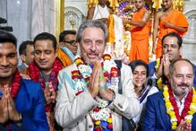 Visitantes cumprimentam num templo hindu com flores