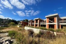 Construções inacabadas em área com vegetação sob céu azul
