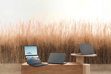 Três portáteis Zenbook da Asus em cima de mesas de madeira