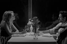 Um homem e uma mulher sentados à mesa num ambiente intimista