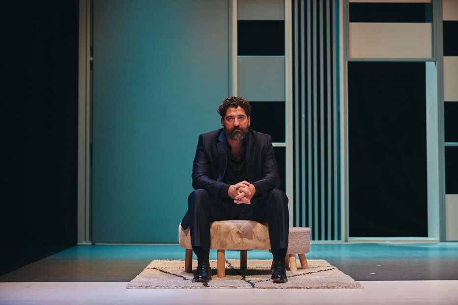 Um homem sentado num banco, de fato