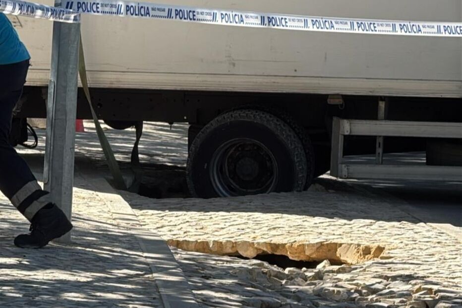 Camião com roda presa em buraco na via pública em Cascais