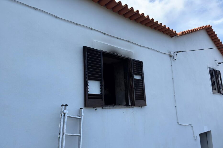 Incêndio danifica janela de casa branca com telhado vermelho