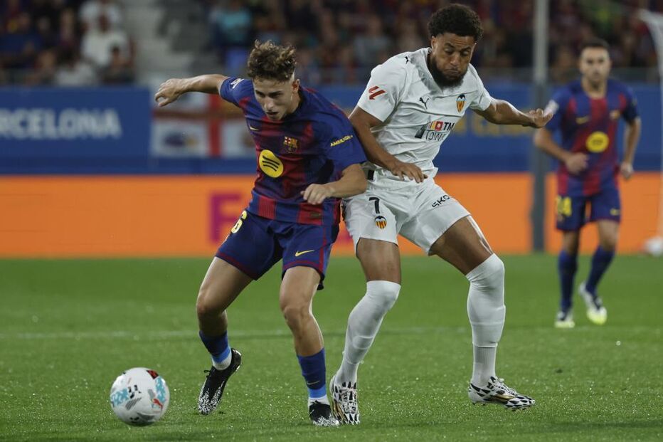 Fermín López e jogador do Valência disputam a bola no jogo em Barcelona